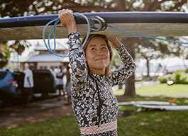 Photo of a woman carrying a surfboard. Link to Life Stage Gift Planner Ages 60-70 Situations.
